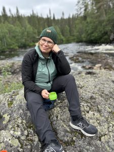 Yrittäjä istuu Oulankajoen rannalla.