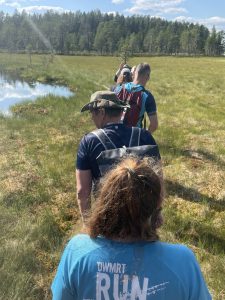 Retkeiljöitä suoalueella pitkospuilla peräkkäin.